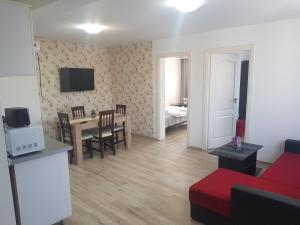 a living room with a red couch and a table at Apartament 11 Central in Târgu-Mureş