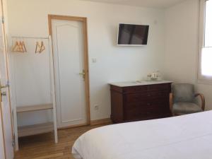 - une chambre avec un lit, une commode et une télévision dans l'établissement Hotel Particulier Richelieu, à Calais