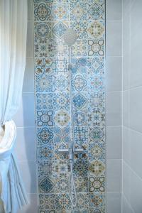 a bathroom with a shower with blue and white tiles at 鴻滿億民宿 in Magong +115 photos