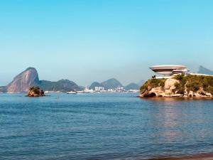 a building on an island in the middle of the water at Viareggio H in Niterói