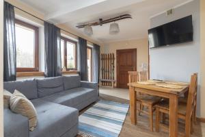 ein Wohnzimmer mit einem Sofa und einem Tisch in der Unterkunft Apartamenty Domino - Zakopane in Zakopane
