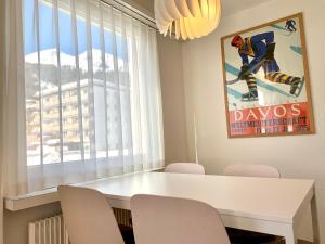 a dining room table with chairs and a movie poster at Holiday apartment Bolgen - close to everything! Bolgen, Jakobshorn, bus stop, train station, supermarket, ski school, ski rentals, restaurants and more! in Davos