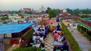 Un gruppo di persone seduti sulle scale di una città di Hotel Saniya Palace inn ad Agra