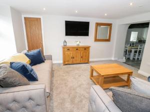 uma sala de estar com dois sofás e uma televisão em The Blue Lion em Cynwyd