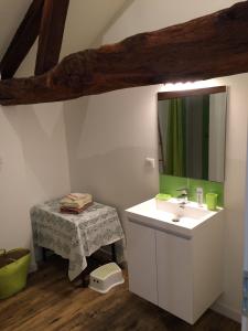 a bathroom with a sink and a mirror and a table at ensemble de deux chambres pour famille in Planioles