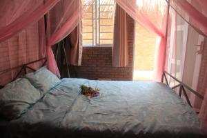um quarto com uma cama com um arranjo de flores em Bầu Bí Mini Farmstay Mekong - Tiền Giang em Mỹ Tho
