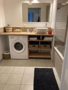 a bathroom with a washing machine and a sink at F3 standing in Les Ulis