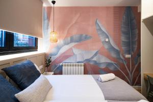 1 dormitorio con 1 cama con un mural en la pared en Home42, en Madrid