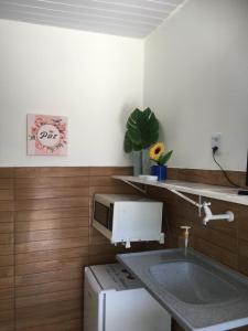 a kitchen with a sink and a microwave at Casa da Adriana Pousada in Fortaleza
