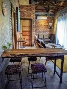 Rumah Bendang Langkawi Villa Pool في بانتايْ سينانج: طاولة خشبية كبيرة في غرفة مع كراسي