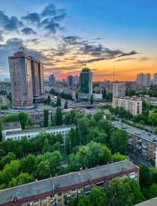 un perfil urbano con edificios altos y árboles al atardecer en VICTORY-21 LUXURY APARTMENT CEnTER, en Kiev