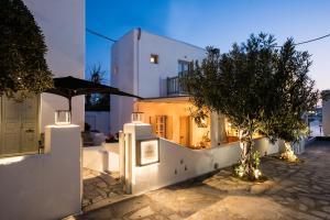 a house with a white fence and trees at night at Island Mykonos Suites in Mikonos