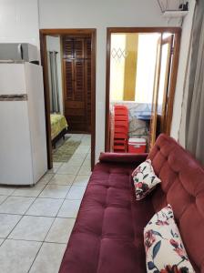 a couch sitting in a living room next to a kitchen at Apartamento Ubatuba - Praia grande - 260m da praia in Ubatuba