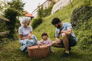 a family sitting in the grass with a basket at Rooms & Apartments Podsreda Castle in Podsreda