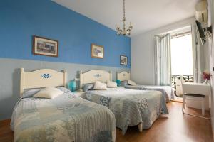- une chambre avec 2 lits aux murs bleus dans l'établissement Hostal Valencia Madrid, à Madrid