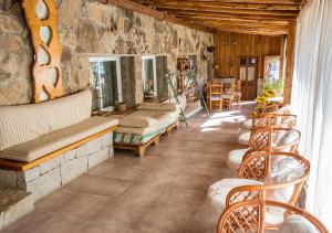 ein Zimmer mit Stühlen und einer Steinmauer in der Unterkunft El Corralon in Casavieja