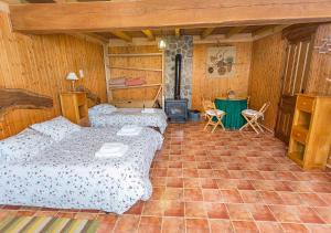 1 Schlafzimmer mit 2 Betten und einem Holzofen in der Unterkunft El Corralon in Casavieja