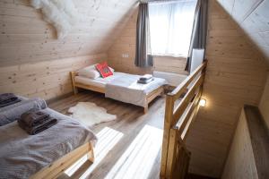 Zimmer im Dachgeschoss mit 2 Betten und einem Fenster in der Unterkunft Willa Mała Łąka Jacuzzi & Sauna in Zakopane
