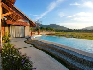 Rumah Bendang Langkawi Villa Pool في بانتايْ سينانج: مسبح بجانب منزل به نهر