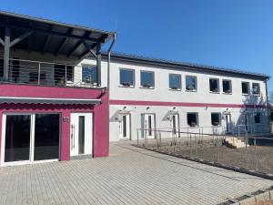 a white and pink building with a lot of windows at Apartmenthaus Krone Wohnen mit Herz in Bexbach