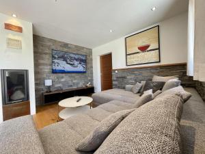 a living room with a couch and a tv at Mona Apartment in Going am Wilden Kaiser