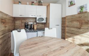 a kitchen with a wooden table and white cabinets at Ferienhaus In Heiligenbrunn in Heiligenbrunn