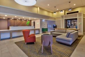 a lobby with chairs and a couch and a table at Holiday Inn Westbury-Long Island, an IHG Hotel in Carle Place