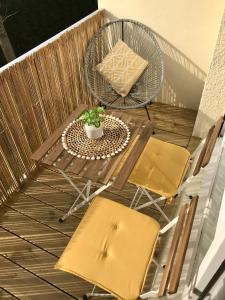 eine Terrasse mit einem Tisch und Stühlen auf dem Balkon in der Unterkunft Cabourg - Bel appartement lumineux avec balcon dans résidence privée in Cabourg