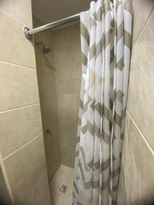 a shower with a shower curtain in a bathroom at WHITE HOUSE in Guayaquil