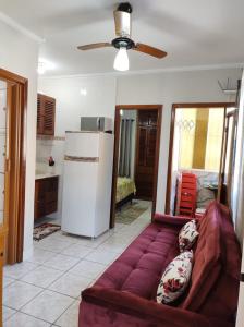 a living room with a couch and a refrigerator at Apartamento Ubatuba - Praia grande - 260m da praia in Ubatuba