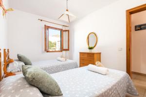 a bedroom with two beds and a mirror at Casa Marinada in Es Mercadal