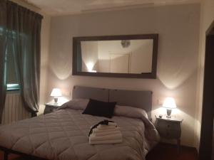 una camera da letto con un letto con uno specchio e due lampade di B&B Principe Calaf 3 a Lucca