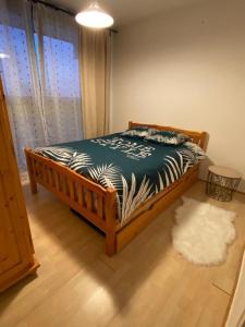 1 dormitorio con 1 cama con sábanas de cebra y alfombra en Au pied des pistes (Le Corbier/73) en Villarembert