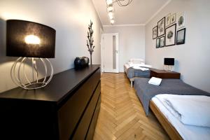 sypialnia z 2 łóżkami i stołem z lampką w obiekcie Hala Mirowska Apartments w Warszawie