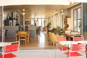 - un restaurant avec des tables et des chaises dans une salle dans l'établissement Auberge des Vergers, à Genève