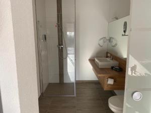 a bathroom with a shower and a toilet and a sink at Apartmenthaus Krone Wohnen mit Herz in Bexbach