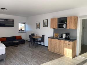 a living room with a couch and a kitchen with a table at Apartmenthaus Krone Wohnen mit Herz in Bexbach