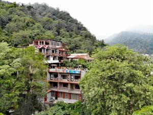 a building on the side of a mountain at Hill Top Swiss Cottage in Rishīkesh