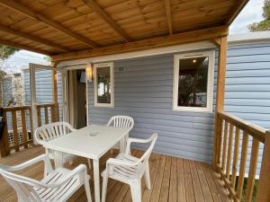 una terraza de madera con mesa y sillas. en Camping Serenella en Bardolino