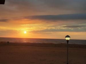 uma luz de rua na praia ao pôr do sol em Rideau Oceanfront Motel em Ocean City