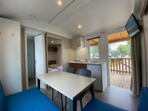 a kitchen and dining room with a white table and chairs at Camping Serenella in Bardolino