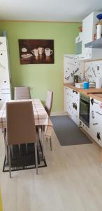 Pfötchen في Mettweiler: مطبخ مع طاولة وكراسي في مطبخ