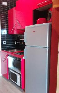 ベナルマデナにあるBenal Beach Suiteのキッチン(赤いキャビネット、白い冷蔵庫付)