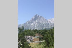 a mountain in the distance with houses and trees at La montagna incantata in Isola del Gran Sasso dʼItalia