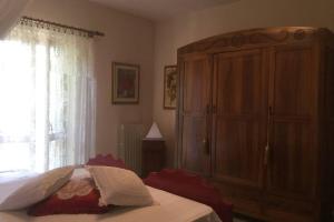a bedroom with a bed and a cabinet and a window at La montagna incantata in Isola del Gran Sasso dʼItalia