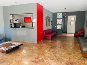 a living room with a couch and a red wall at Viareggio H in Niterói