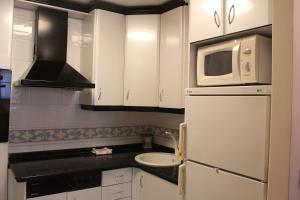 a kitchen with a white refrigerator and a microwave at INSIDEHOME Apartments - Ático del Val in Valladolid