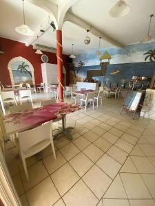 a dining room with tables and chairs and a mural at Appartement lumineux à Pointe-Noire avec piscine partagée in Pointe-Noire
