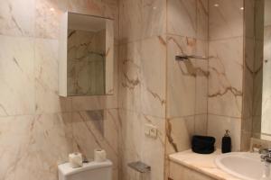 a bathroom with a sink and a toilet and a mirror at INSIDEHOME Apartments - Ático del Val in Valladolid +24 photos