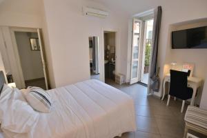 a bedroom with a white bed and a table and chairs at La Terrazza Vercelli Bed & Charme in Vercelli